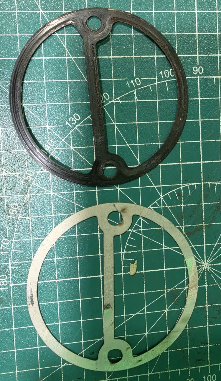 Customer-supplied circular sample alongside the newly cut circular part on a green cutting mat.
